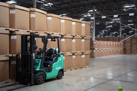Forklift parked near stacked bulk containers in warehouse