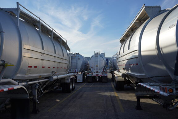Line of transport trailers positioned at logistics yard during staging operations