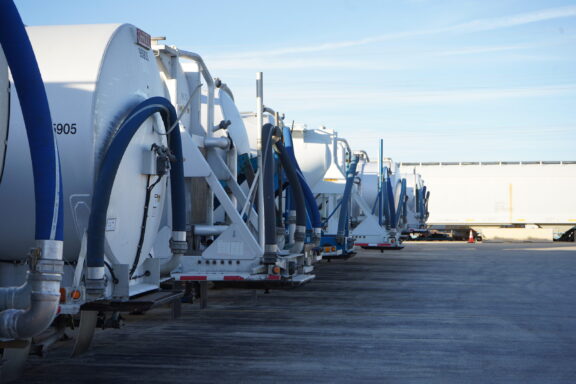 Row of Quantix transport trailers staged with connected hoses for logistics operations