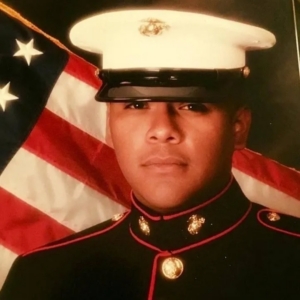 US Marine in dress uniform with American flag background