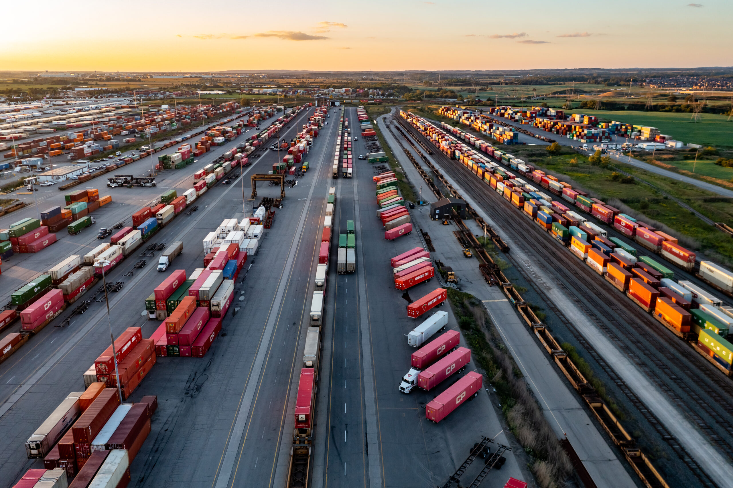Intermodal yard with trucks and trains at sunset