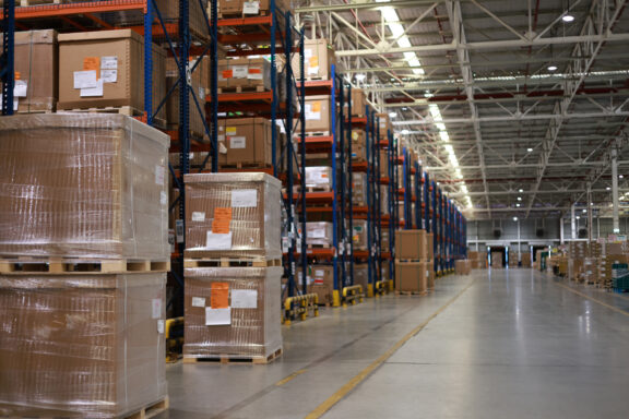 Warehouse aisles lined with stacked pallets and high racks